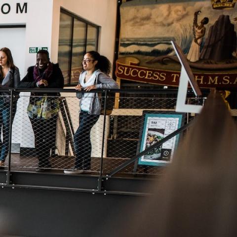 Female students in museum looking at antique boat